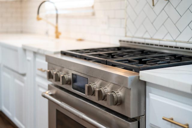 2048 W Sierra Ave, Fresno, CA 93711 - kitchen view of high end stainless steel range, tasteful backsplash, and white cabinets