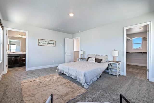 1276 Sauret St, Madera, CA 93638 - bedroom with light carpet, baseboards, a sink, a walk in closet, and ensuite bathroom