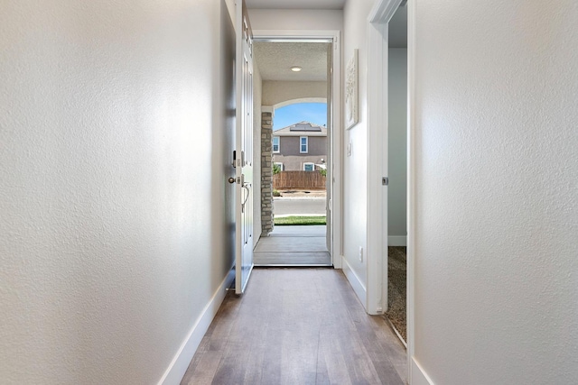 1276 Sauret St, Madera, CA 93638 - doorway to outside featuring dark wood-style flooring, baseboards, and a textured wall