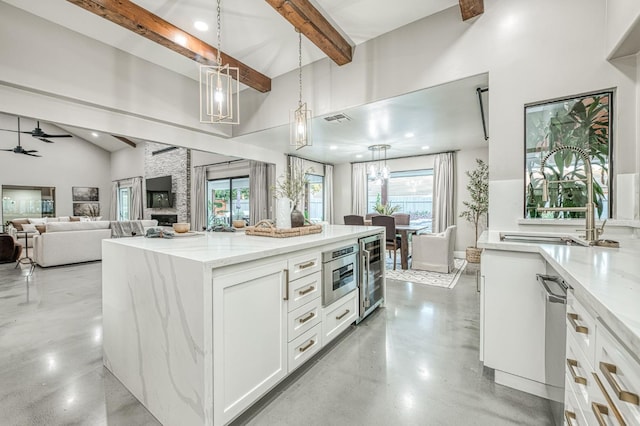 3841 W Alluvial Ave, Fresno, CA 93711 - kitchen with beam ceiling, white cabinetry, wine cooler, light stone counters, and finished concrete floors