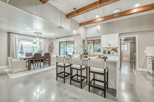 3841 W Alluvial Ave, Fresno, CA 93711 - kitchen with a breakfast bar, light countertops, concrete flooring, white cabinets, and beam ceiling
