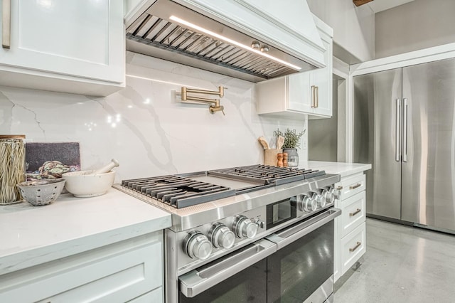 3841 W Alluvial Ave, Fresno, CA 93711 - kitchen with stainless steel appliances, wall chimney exhaust hood, white cabinets, and light stone counters