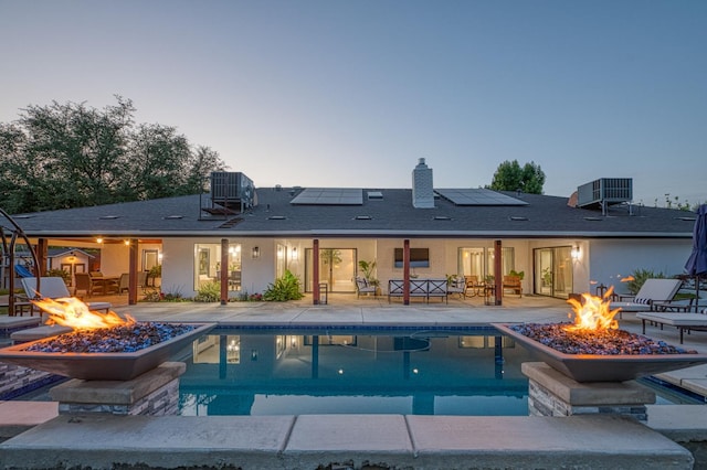 3841 W Alluvial Ave, Fresno, CA 93711 - back of house at dusk with a fire pit, a patio area, and an outdoor pool
