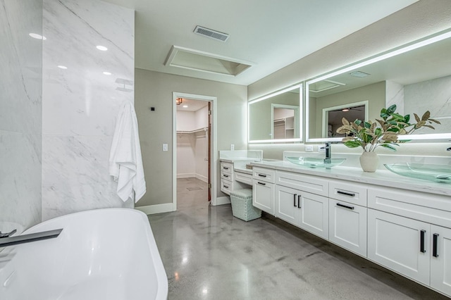 3841 W Alluvial Ave, Fresno, CA 93711 - full bathroom featuring double vanity, a freestanding tub, a walk in closet, finished concrete flooring, and baseboards