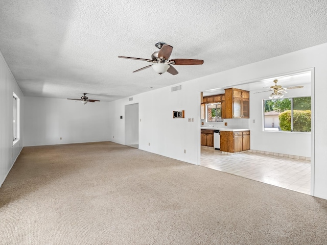 6413 N 5th St, Fresno, CA 93710 - unfurnished living room with ceiling fan, a textured ceiling, light carpet, and a sink