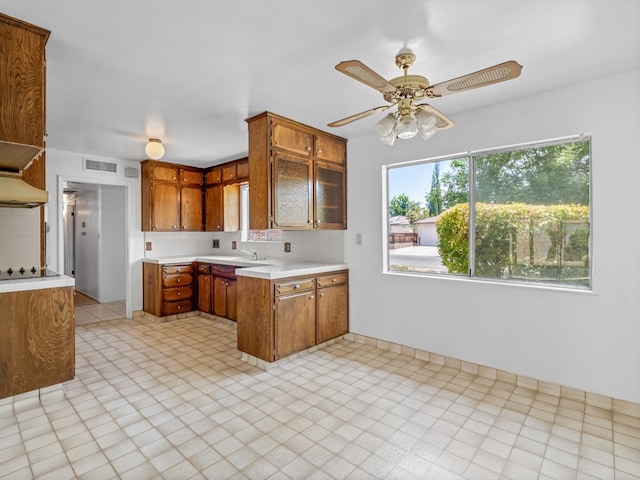 6413 N 5th St, Fresno, CA 93710 - kitchen featuring brown cabinetry, light countertops, ceiling fan, and a sink