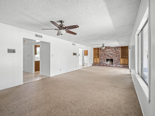 6413 N 5th St, Fresno, CA 93710 - unfurnished living room with ceiling fan, a brick fireplace, a textured ceiling, light carpet, and baseboards