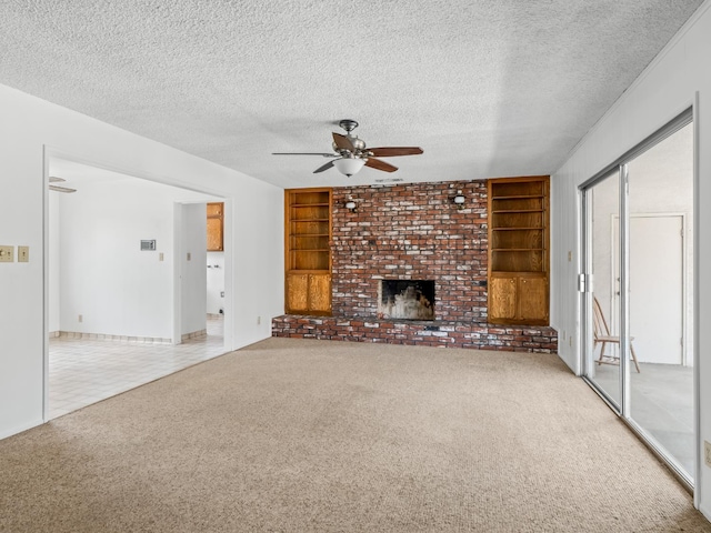 6413 N 5th St, Fresno, CA 93710 - unfurnished living room featuring ceiling fan, carpet floors, built in shelves, a textured ceiling, and a brick fireplace