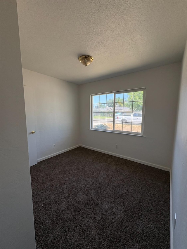 4664 E Browne St, Fresno, CA 93703 - spare room featuring dark colored carpet, baseboards, and a textured ceiling