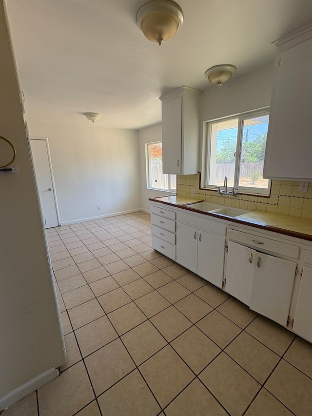 4664 E Browne St, Fresno, CA 93703 - kitchen with backsplash, a sink, light tile patterned floors, white cabinets, and tile countertops
