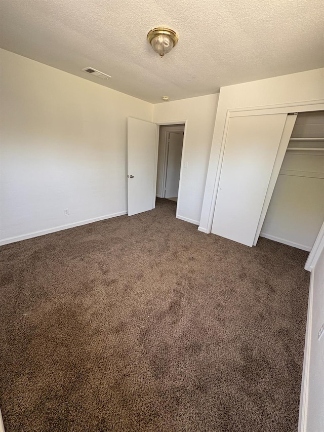 4664 E Browne St, Fresno, CA 93703 - unfurnished bedroom featuring dark colored carpet, a textured ceiling, baseboards, and a closet
