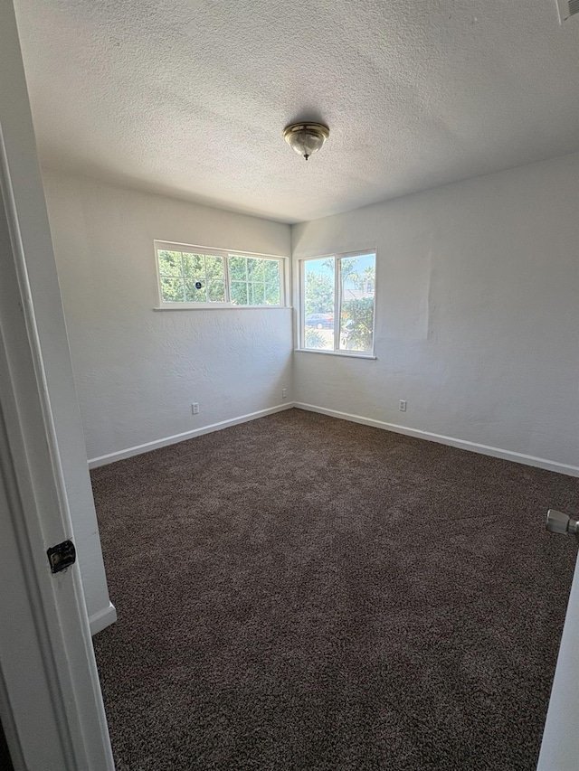 4664 E Browne St, Fresno, CA 93703 - empty room with a textured ceiling, dark carpet, and baseboards