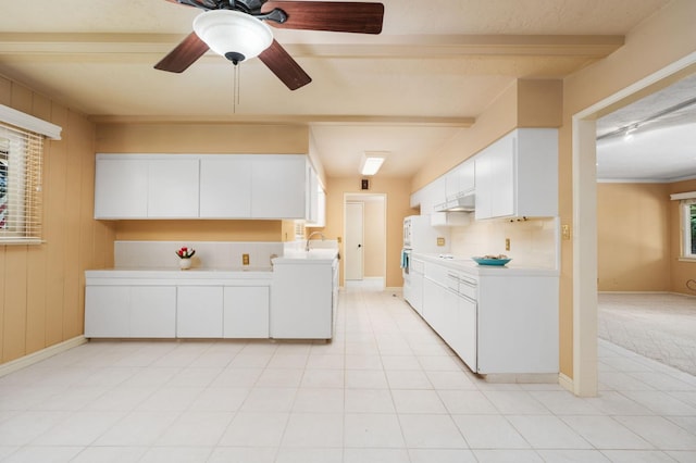 5835 E Hamilton Ave, Fresno, CA 93727 - kitchen with under cabinet range hood, light countertops, white cabinetry, a sink, and ceiling fan
