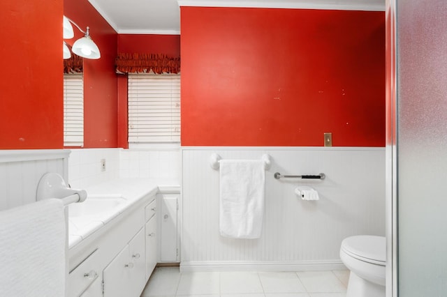 5835 E Hamilton Ave, Fresno, CA 93727 - bathroom featuring a wainscoted wall, toilet, vanity, tile patterned floors, and crown molding