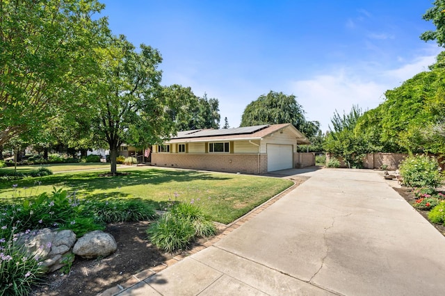 5835 E Hamilton Ave, Fresno, CA 93727 - ranch-style house with brick siding, solar panels, concrete driveway, and an attached garage