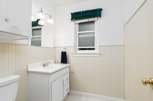 5835 E Hamilton Ave, Fresno, CA 93727 - bathroom with vanity, wainscoting, toilet, tile patterned flooring, and wood walls