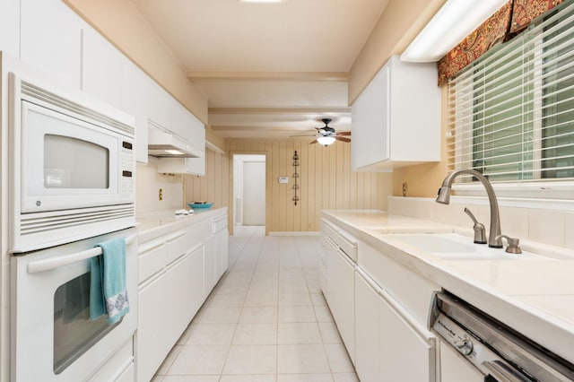 5835 E Hamilton Ave, Fresno, CA 93727 - kitchen featuring white appliances, a sink, white cabinetry, light countertops, and wooden walls