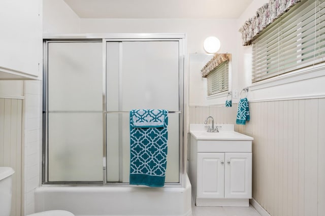 5835 E Hamilton Ave, Fresno, CA 93727 - full bathroom with vanity, toilet, a wainscoted wall, tile patterned flooring, and enclosed tub / shower combo