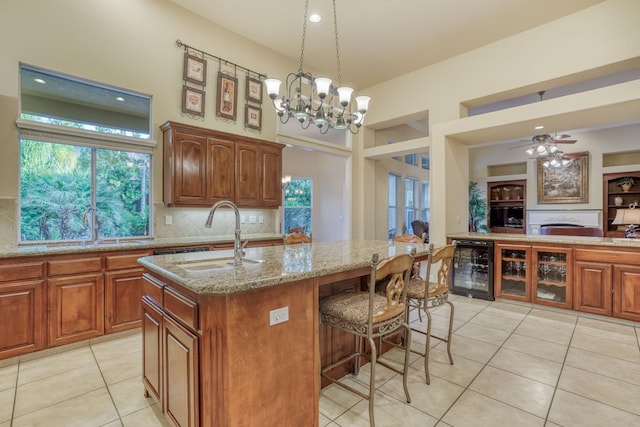 1223 E Rosemont Ln, Fresno, CA 93730 - kitchen featuring a sink, beverage cooler, light tile patterned flooring, and light stone countertops