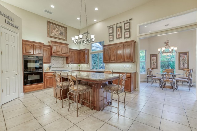 1223 E Rosemont Ln, Fresno, CA 93730 - kitchen with a chandelier, a towering ceiling, light tile patterned floors, backsplash, and recessed lighting