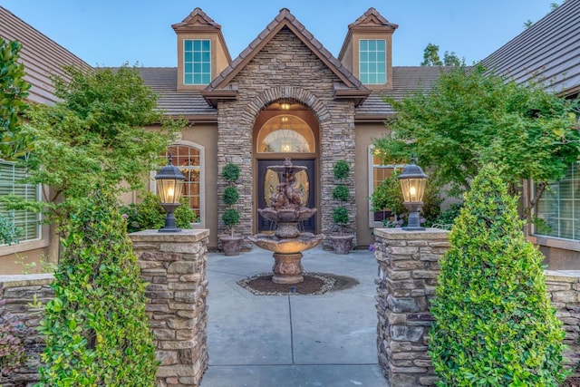 1223 E Rosemont Ln, Fresno, CA 93730 - property entrance featuring stucco siding, a tile roof, and stone siding