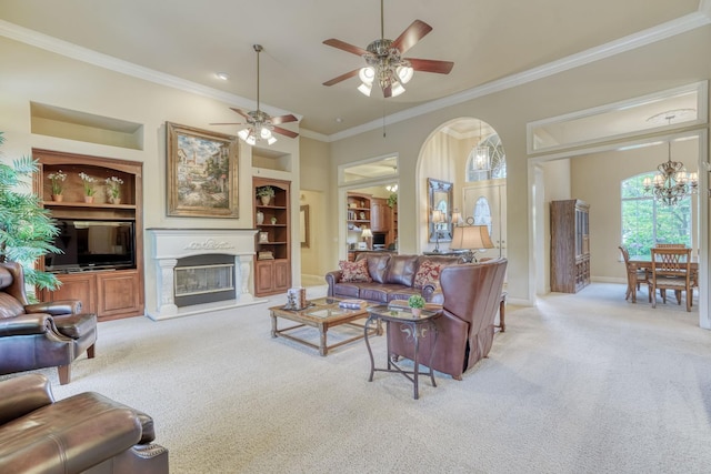 1223 E Rosemont Ln, Fresno, CA 93730 - living area featuring light colored carpet, built in features, a glass covered fireplace, ornamental molding, and arched walkways