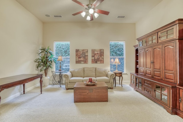 1223 E Rosemont Ln, Fresno, CA 93730 - living room featuring a ceiling fan, light colored carpet, healthy amount of natural light, and baseboards