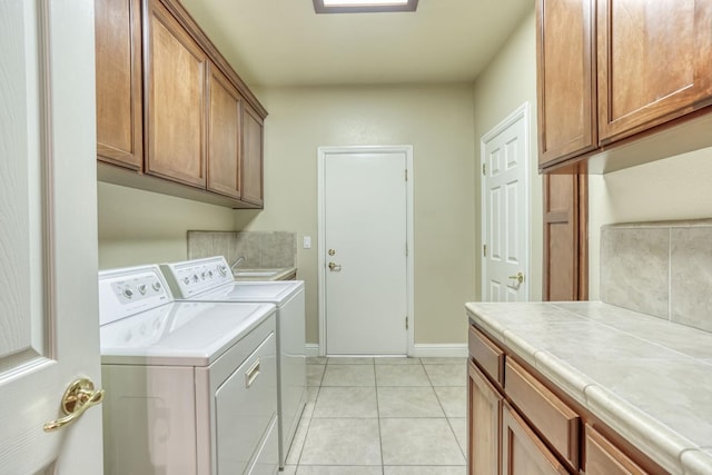 1223 E Rosemont Ln, Fresno, CA 93730 - laundry area featuring cabinet space, washer and clothes dryer, light tile patterned floors, and baseboards