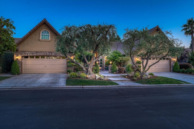 1223 E Rosemont Ln, Fresno, CA 93730 - obstructed view of property with driveway, stucco siding, and an attached garage