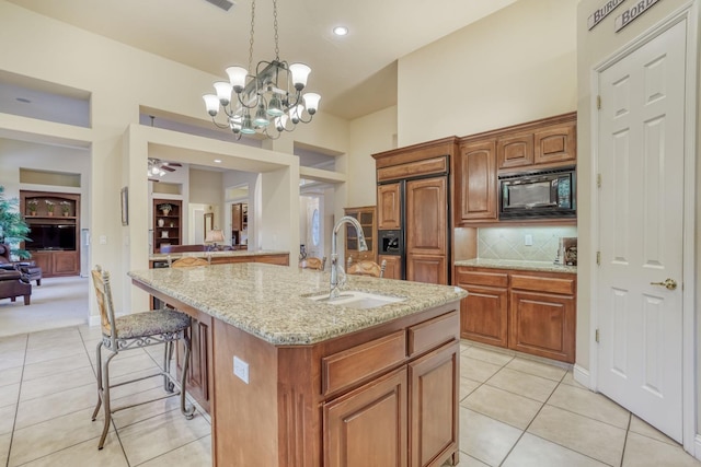 1223 E Rosemont Ln, Fresno, CA 93730 - kitchen featuring a sink, built in appliances, light tile patterned floors, and a breakfast bar