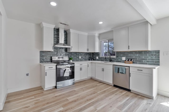 3678 N 7th St, Fresno, CA 93726 - kitchen featuring stainless steel appliances, wall chimney exhaust hood, light countertops, a sink, and light wood-type flooring
