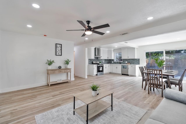 3678 N 7th St, Fresno, CA 93726 - living room featuring ceiling fan, baseboards, recessed lighting, and light wood-type flooring
