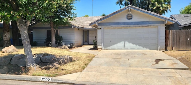 5092 W Stuart Ave, Fresno, CA 93722 - ranch-style home with a tile roof, driveway, and an attached garage