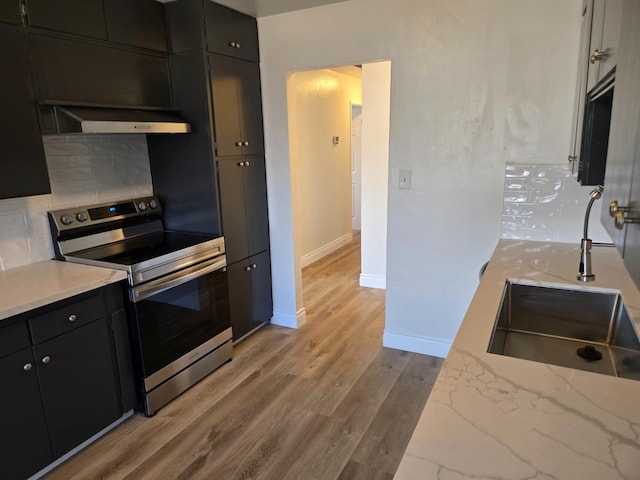 2018 E Pico Ave, Fresno, CA 93726 - kitchen featuring stainless steel electric range oven, under cabinet range hood, dark cabinetry, tasteful backsplash, and baseboards