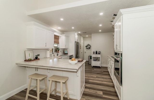 736 N Dartmouth Ave, Clovis, CA 93611 - kitchen featuring appliances with stainless steel finishes, a sink, a peninsula, recessed lighting, and dark wood finished floors