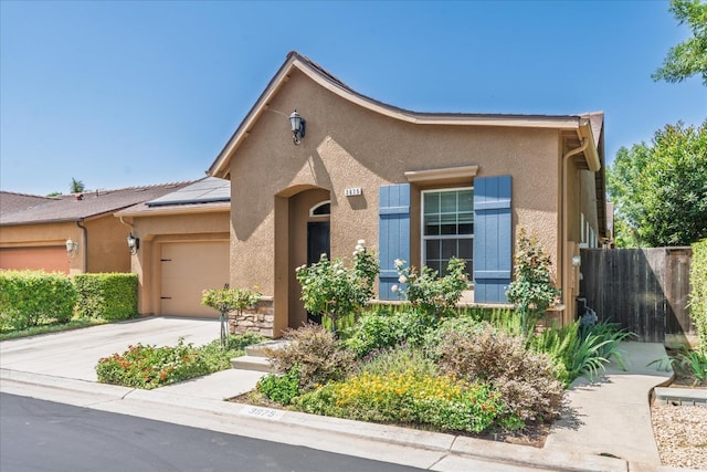 3675 Trenton Ln, Clovis, CA 93619 - view of front of property with stucco siding, a garage, solar panels, and driveway