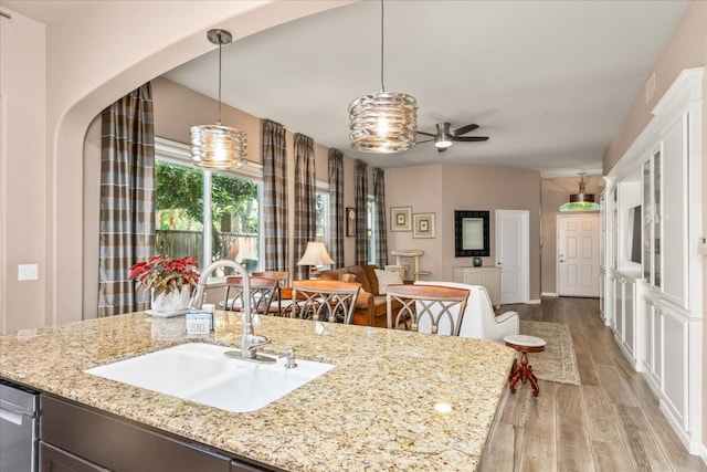 3675 Trenton Ln, Clovis, CA 93619 - kitchen with a sink, light wood-type flooring, open floor plan, arched walkways, and pendant lighting