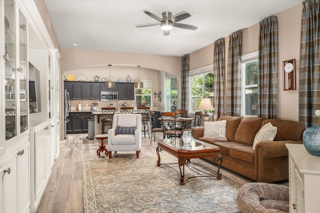 3675 Trenton Ln, Clovis, CA 93619 - living area featuring light wood finished floors, arched walkways, and a ceiling fan