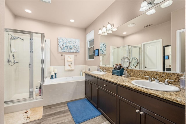 3675 Trenton Ln, Clovis, CA 93619 - bathroom featuring wood finished floors, a shower stall, double vanity, a bath, and recessed lighting