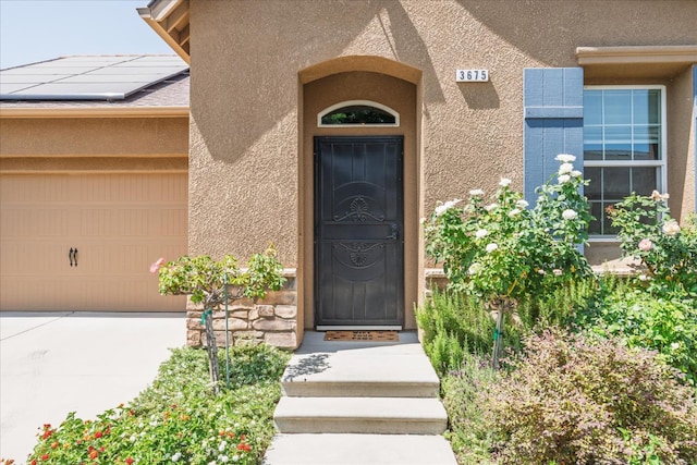 3675 Trenton Ln, Clovis, CA 93619 - entrance to property featuring stucco siding, roof mounted solar panels, and a garage