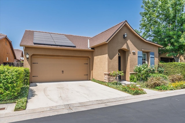 3675 Trenton Ln, Clovis, CA 93619 - view of front of home with stucco siding, solar panels, an attached garage, and concrete driveway