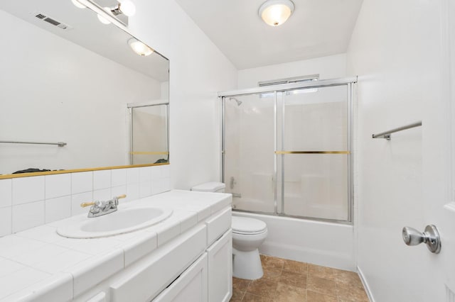 6051 N Tracy Ave, Fresno, CA 93722 - bathroom with toilet, vanity, decorative backsplash, and bath / shower combo with glass door