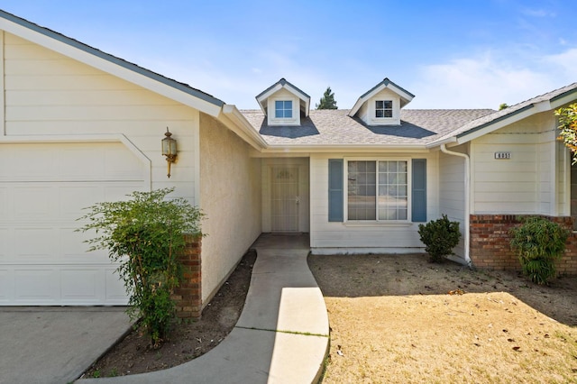 6051 N Tracy Ave, Fresno, CA 93722 - property entrance with a garage, roof with shingles, and brick siding