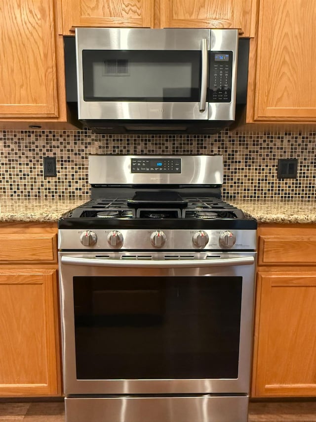 9850 N Winery Ave, Fresno, CA 93720 - kitchen with appliances with stainless steel finishes, tasteful backsplash, and light stone counters