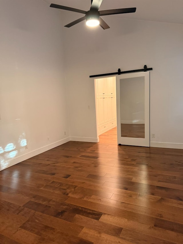 9850 N Winery Ave, Fresno, CA 93720 - spare room with a barn door, a ceiling fan, baseboards, wood finished floors, and a towering ceiling