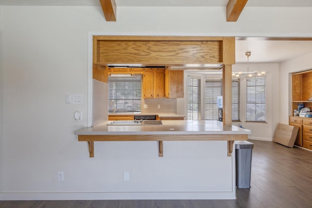 300 W Adrian Way, Hanford, CA 93230 - kitchen featuring beamed ceiling, a kitchen bar, a chandelier, dark wood-style flooring, and light countertops