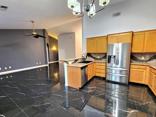 9438 N Ann Ave, Fresno, CA 93720 - kitchen with stainless steel appliances, a sink, a peninsula, ceiling fan, and dark marble finish flooring