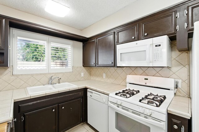 4849 N 7th St Unit E, Fresno, CA 93726 - kitchen with white appliances, a sink, dark brown cabinets, a textured ceiling, and decorative backsplash