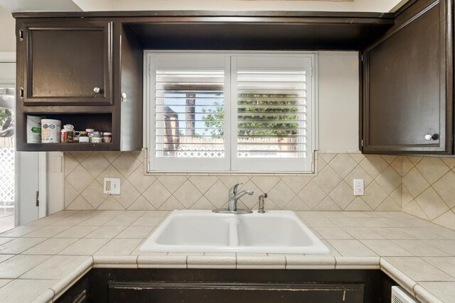 4849 N 7th St Unit E, Fresno, CA 93726 - kitchen featuring dark brown cabinetry, a sink, and decorative backsplash