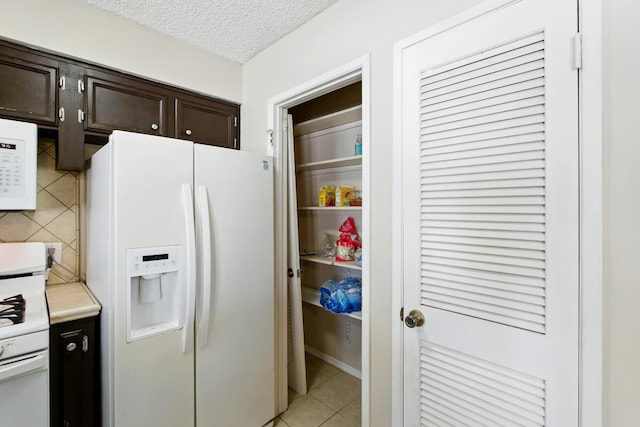 4849 N 7th St Unit E, Fresno, CA 93726 - kitchen featuring white appliances, dark brown cabinets, light countertops, light tile patterned floors, and a textured ceiling